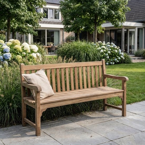 Houten 2-zits tuinbank met een linnen kussen in een weelderige tuin.