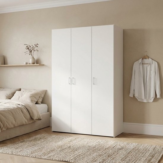 Witte driedeurskast in een slaapkamer, naast een bed met gestreken kleding.
