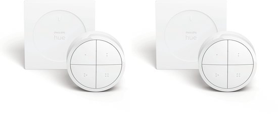 Twee witte Philips Hue draaiknoppen met vier knoppen per stuk, naast hun verpakkingen.