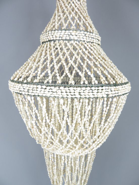 Lichtgrijze achtergrond met een lamp van witte schelpen op een metalen frame in het midden.