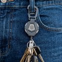 Porte-clés rétractable noir avec mousqueton sur un jean, avec un trousseau de clés attaché.