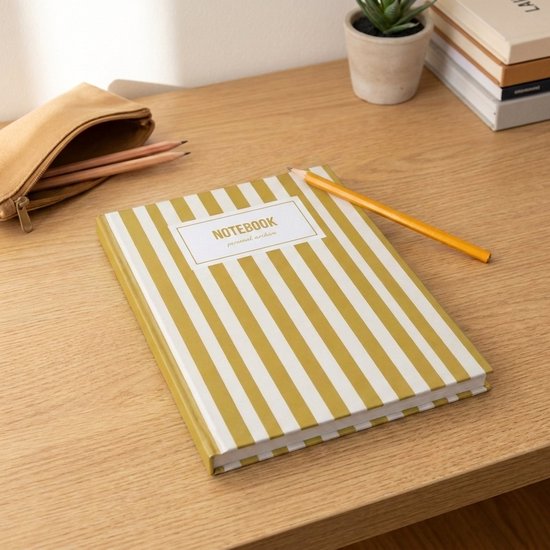 Gestreept geel notitieboek op een houten bureau, met potloden en een etui.