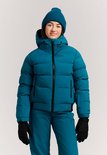 Meisje in blauwe ski-jas, bijpassende muts, broek en zwarte handschoenen. "protest" logo op de jas.