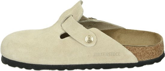 Sandkleurige suède Birkenstock clog met gesp en suède afwerking, merknaam zichtbaar.