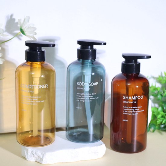 Trois flacons rechargeables avec pompes : après-shampoing ambré, savon corporel bleu et shampoing ambré.