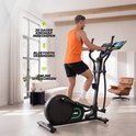 Man traint op een zwarte crosstrainer in een woonkamer en kijkt naar het tablet-scherm met trainingsprogramma.
