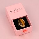 Gouden ring met tijgeroog edelsteen in een roze My Bendel sieradendoosje.