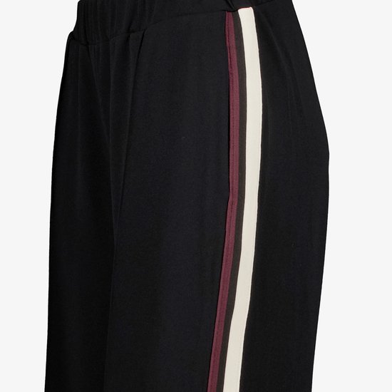 Zwarte broek met aan de zijkant een witte bies met aan weerszijden een bordeauxrode bies.