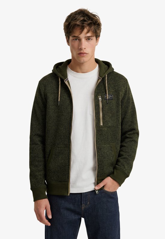 Model draagt een olijfgroene, gemêleerde fleece hoodie met rits, beige accenten en Superdry & Co-badge.