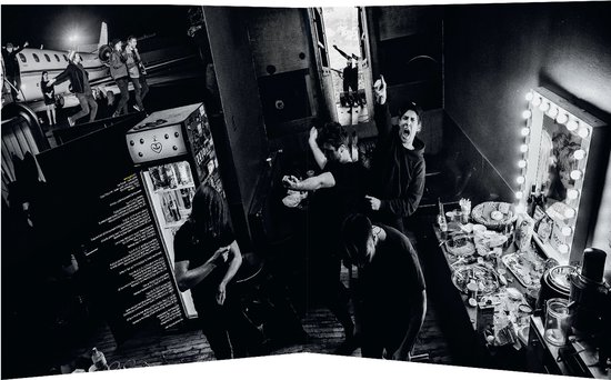 De band Kensington in een kleedkamer met een vliegtuig op de achtergrond, backstage.
