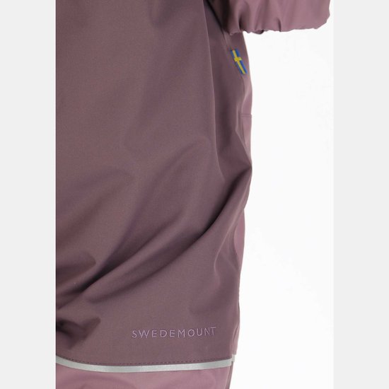 Detailopname van een paarse overall met reflecterende streep en het Swedemount-logo onderaan.