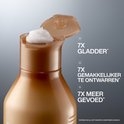 Gros plan de l'ouverture d'une bouteille Redken avec une noix de crème. Texte : '7 FOIS PLUS SOUPLE*', '7 FOIS PLUS FACILE À DÉMÊLER*', '7 FOIS PLUS NOURRI*'.