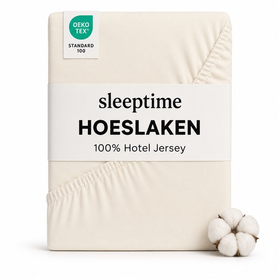 Gevouwen crèmekleurig Sleeptime Jersey hoeslaken met OEKO-TEX keurmerk en katoenbol.