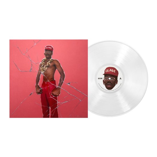 Un homme en pantalon rouge et casquette "GLASS", portant une grosse chaîne en or. À côté de la pochette se trouve un disque vinyle transparent.