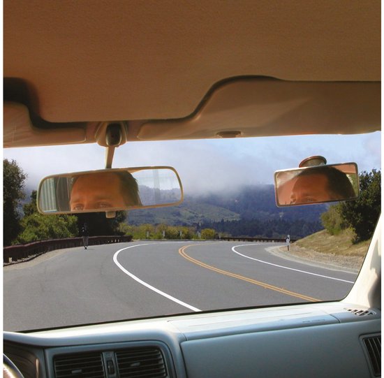 Reflectie van een gezicht in twee autospiegels, met een bochtige weg op de achtergrond.
