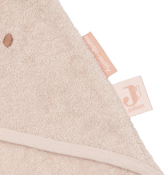 Gros plan d'une cape de bain rose avec des oreilles de lapin, un visage brodé et les étiquettes 'nOthinje miffy' et 'Jollein'.