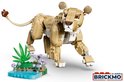 Gele lego leeuwin met bruine oren, witte tanden en een waterige, groene ondergrond met paarse bloemen.