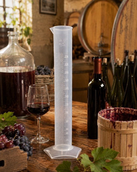 Transparante maatcilinder van 250 ml met schaalverdeling, staand op een houten tafel tussen wijnflessen en druiven.