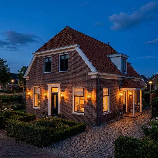 Buitenlampen aan een bakstenen huis, verlichten de voortuin en oprit bij avond.