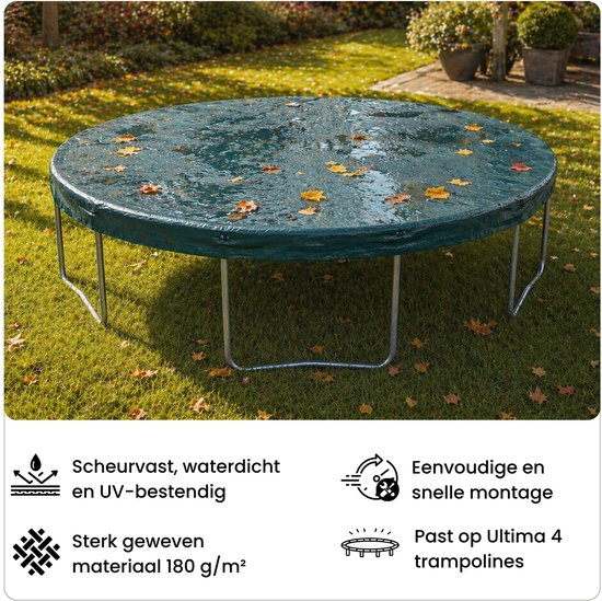 Ronde trampolinehoes in groen, bedekt met bladeren, staat op een grasveld.