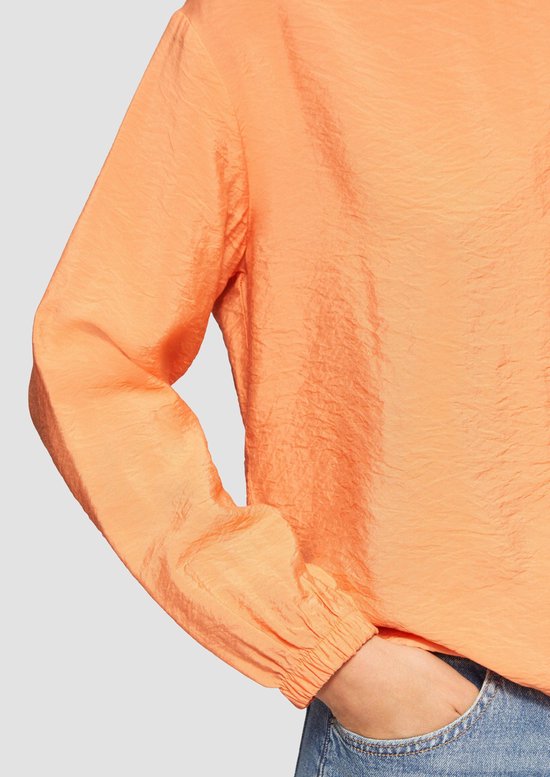 Detail van de oranje s.Oliver blouse met kreukeleffect en trekkoord.