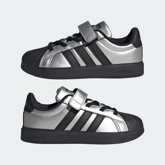 Twee zilverkleurige sneakers met zwarte strepen, klittenband en neus.