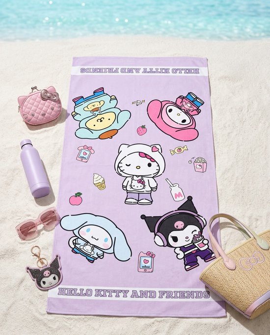 Lila strandlaken met Hello Kitty en vrienden, liggend op zand. Bevat o.a. My Melody, Kuromi en Cinnamoroll.