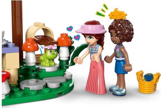 Twee LEGO Friends meisjes bij een bosfeest met kikker, paddenstoelen en een mand met bosbessen.