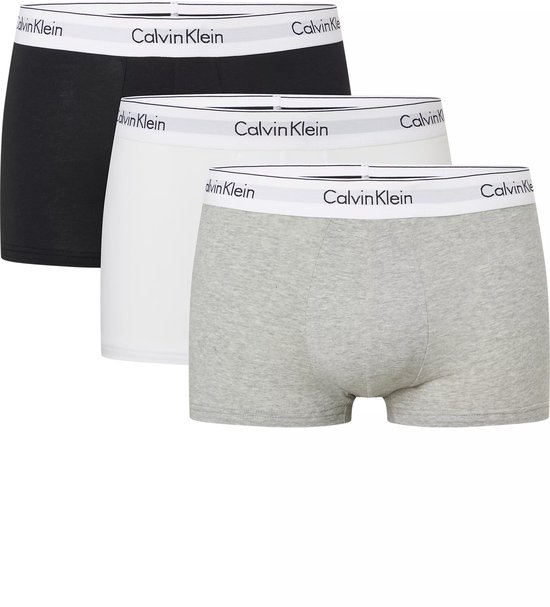 Drie Calvin Klein trunks: één zwarte, één witte en één grijze boxer. Allen met witte Calvin Klein band.