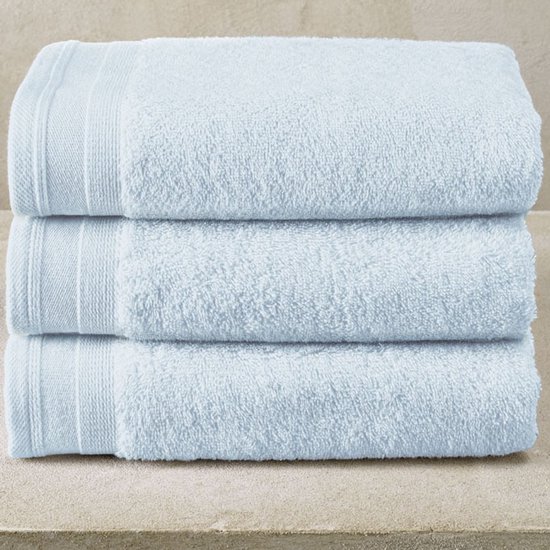Trois serviettes bleu pâle empilées, texture douce et moelleuse, avec une subtile bordure sur le dessus.