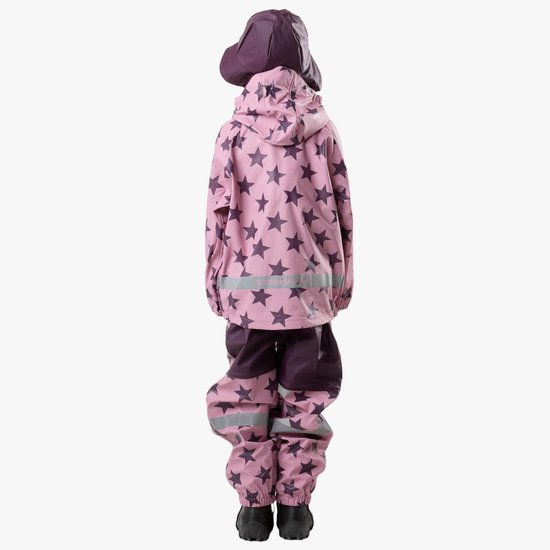 Meisje van achteren gezien, staand in een compleet roze regenpak met donkerpaarse sterrenprint, met hoed, en zwarte laarzen.