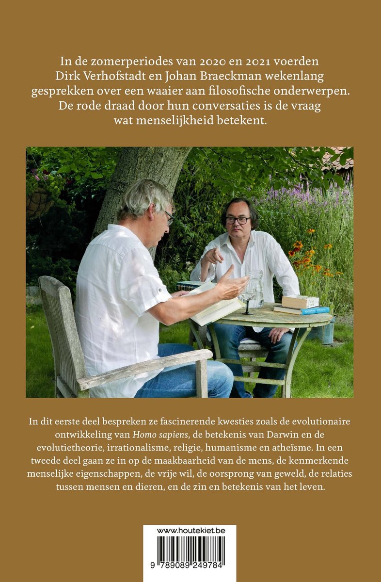 Twee mannen in een tuin bij een tafel, een met een boek in zijn handen. De tekst is in het Nederlands.