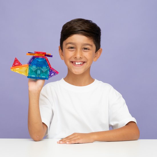Jongen houdt een helikopter vast, gemaakt van Connetix magnetische tegels in regenboogkleuren.