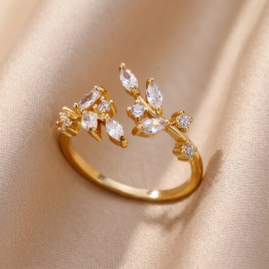 Bague dorée avec motif de feuilles ouvertes et zircons.