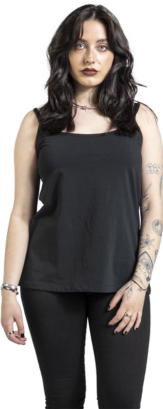 Model in zwarte tanktop met gekruiste bandjes op de rug, met tatoeages op de armen.
