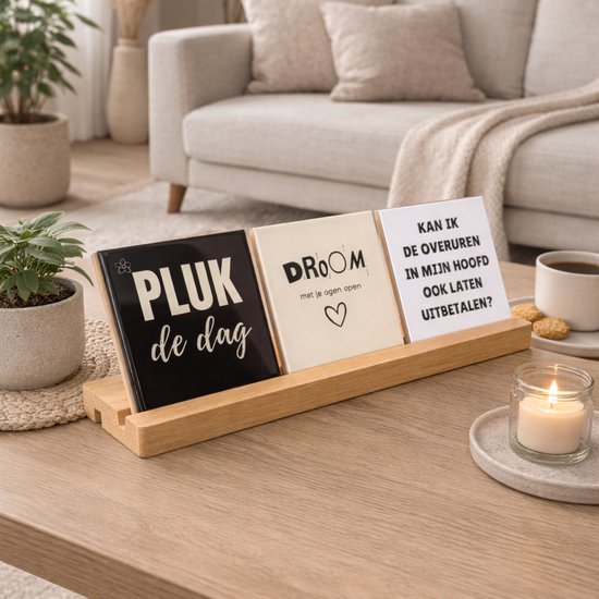 Un support en bois pour trois carreaux. Les carreaux portent les textes 'PLUK de dag', 'DROOM met je ogen open' et 'KAN IK DE OVERUREN IN MIJN HOOFD OOK LATEN UITBETALEN?'.