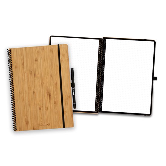 Een Bambook notitieboek met bamboe kaft en elastische band, opengeklapt met dotted pagina's. Een pen is zichtbaar.