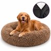 Een blije golden retriever ligt in een grote, bruine, pluizige donutmand.