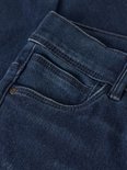Detail van de zakken en het denim van een donkerblauwe skinny jeans.