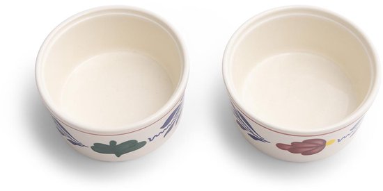 Twee crème ramkinkjes met rode en blauwe bloemen en bladeren decoratie.