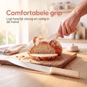 Hand wordt geholpen door een Broba broodmes met houten handvat dat stoom uit een vers gesneden brood snijdt. "Comfortabele grip"
