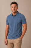 Man met een blauw poloshirt met korte mouwen en beige broek.