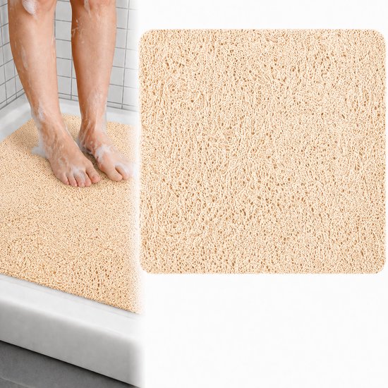 Beige antislip douchemat met een open structuur, waterdoorlatend. Voeten met schuim op de mat in de douche.