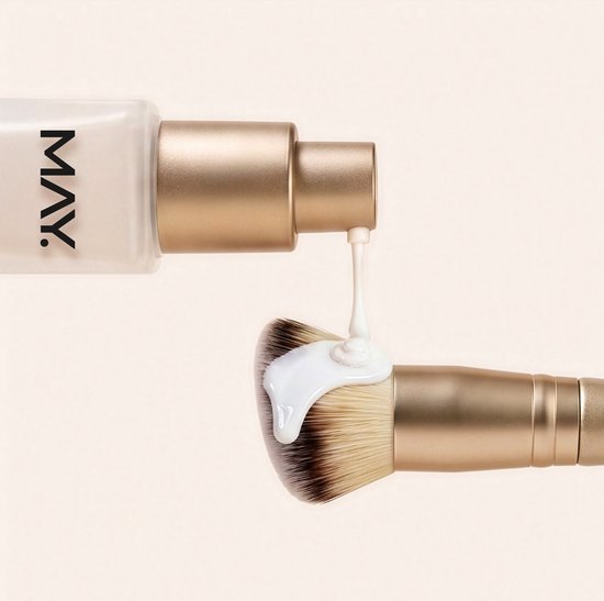 Gouden make-up kwast met witte foundation erop gedruppeld uit een gouden pompflacon.