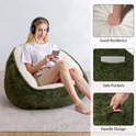 Een vrouw met koptelefoon en telefoon zit in een groene avocadovormige zitzak, met details over de veerkracht en zakken.