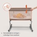 Baby in een lichtbruine co-sleeper met makkelijk te reinigen, wasbare hoes.