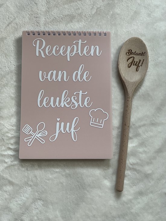 Roze receptenboekje met witte tekst 'Recepten van de leukste juf'. Houten lepel met tekst 'Bedankt Juf!'.