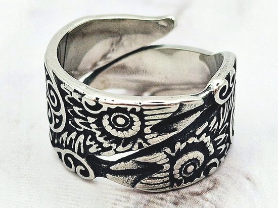 Close-up van een zilverkleurige ring met gedetailleerd Viking Raven patroon.