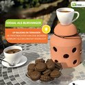 Terracotta kaarsenwarmer als decoratief sfeerlicht op een balkon, met kopjes koffie en koekjes.