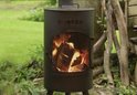 Zwarte, staande BonFeu tuinhaard met brandend hout in de kachel en een gaasdeur.